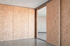 an empty room with wooden walls and concrete flooring on the wall is seen in this image