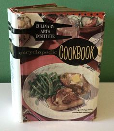 the cookbook is sitting on top of a table with green beans and other food