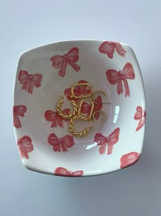 a white plate with red flowers on it and a gold brooch in the center