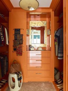 an orange closet with lots of shoes and handbags