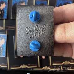 someone is holding up some blue studs on their thumbnails that say bookish stuff