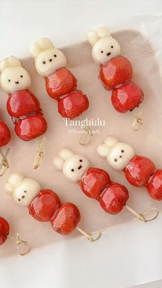 there are many red and white teddy bears on skewers