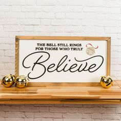 the bell still rings for those who truly believe sign with gold bells on a shelf