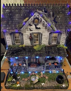 a doll house with lights and decorations on the roof