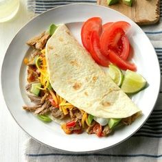 a white plate topped with meat and veggies next to a glass of milk