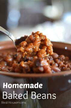 a spoon full of baked beans in a bowl with the words homemade baked beans above it