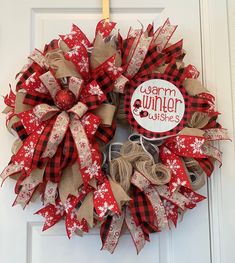 a red and white christmas wreath hanging on a door with the words warm winter wishes