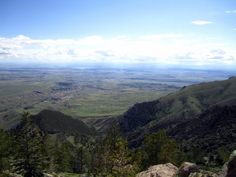 the view from the top of a mountain looking down on mountains and valleys in the distance