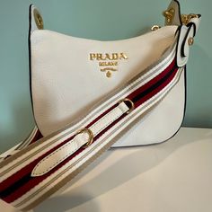 New Prada Logo Shoulder Bag ,Color Bianco, Comes With Tags , Dustbag And Shoping Bag. About The Brand: Classic, Sporty, Signature Style From Italy. Made In Italy Logo Leather Shoulder Bag In Cream Leather And Gold-Plated Hardware With Metal Lettering Logo Interior Design Details: Leather Lining, Zippered Pocket Measures 10inch Wide X 9 Inch High X 3.5in Deep Removable Shoulder Strap Drops 14in Zipper Closure Please Note: All Measurements Were Taken By Hand And Are Approximate; Slight Variations Designer Shoulder Bag With Gold-tone Hardware For Errands, High-end White Bag With Adjustable Strap, Designer Shoulder Bag With Adjustable Strap For Errands, Designer Shoulder Bag With Branded Hardware For Errands, Designer Cream Bag With Leather Lining, Luxury White Pouch Shoulder Bag, Classic White Pouch Shoulder Bag, Luxury White Shoulder Bag With Adjustable Strap, High-end White Shoulder Bag With Detachable Strap