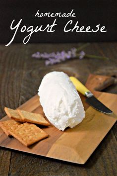 homemade yogurt cheese is on a cutting board with crackers and a knife