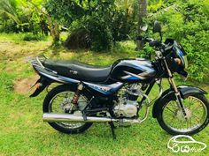 a blue and black motorcycle parked in the grass