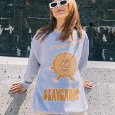 Women's printed sweatshirt with “Staycation” slogan and vintage style sun character graphic. Get set for a Staycation summer in this retro slogan sweater. Super-comfy, oversized fit. This item makes a fun gift for friends and family and it's a must-have for your summer staycation wardrobe.All Batch1 products are lovingly designed, printed and packed by hand in the UK at Batch1 HQ.  Our garments are made to order to minimise wastage and printed using water-based, eco-friendly inks. We are committ Oversized Comfortable Sweatshirt With Graphic Print, Sporty Summer Sweatshirt For Leisure, Sporty Summer Leisure Sweatshirt, Oversized Graphic Print Sweatshirt For Weekend, Sporty Graphic Print Tops For The Weekend, Casual Crew Neck Sweatshirt With Front Print, Retro Screen Print Sweatshirt For Loungewear, Retro Sweatshirt With Screen Print For Loungewear, Spring Weekend Sweatshirt With Letter Print