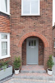 a brick building with two planters on either side and a door in the middle