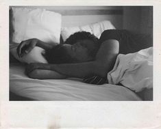 black and white photograph of a woman laying in bed with her head on the pillow