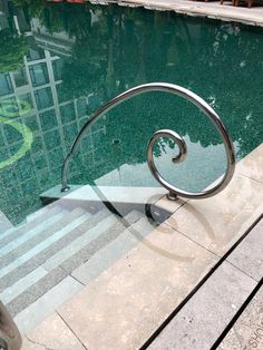 an artistic metal sculpture next to a swimming pool