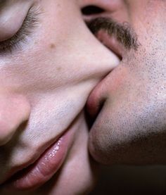 a man and woman kissing each other with their eyes closed