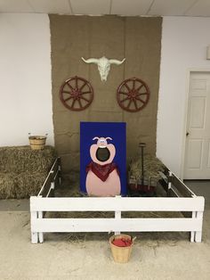 a white bench sitting in front of a wall with a cow head on it's back