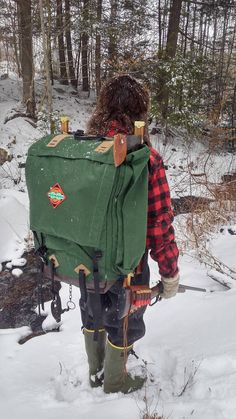 a man walking through the snow carrying a backpack