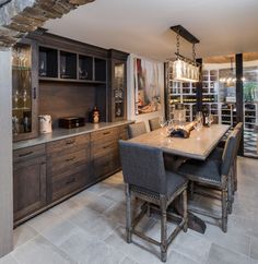 a dining room table and chairs with wine glasses on the shelves in front of it