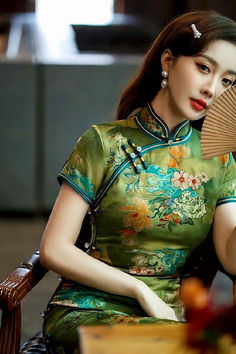 Green qipao dress with a traditional style and a standing mandarin collar Green Elegant Cheongsam With Stand Collar, Elegant Green Cheongsam With Stand Collar, Green Stand Collar Cheongsam For Spring, Spring Green Cheongsam With Stand Collar, Traditional Dresses For Tea Ceremony, Elegant Green Dress For Traditional Ceremonies, Elegant Green Dress With Stand Collar, Green Spring Wedding Cheongsam, Spring Wedding Green Cheongsam