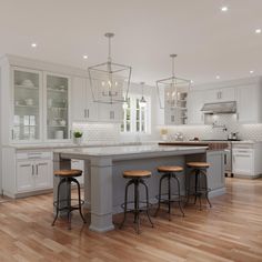 a large kitchen with white cabinets and wooden floors