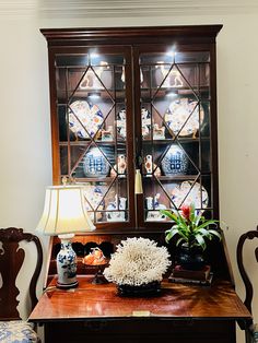 a dining room table with two chairs and a china cabinet