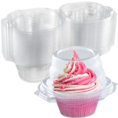 three cupcakes with pink frosting and white icing in plastic containers on a white background