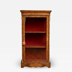 an old wooden cabinet with red shelves and gold trimmings on the top shelf