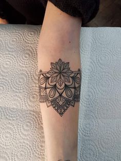 a woman's leg with a tattoo on it and an armband that has a flower