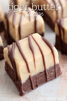 some brownies with white frosting and chocolate drizzled over them on a table