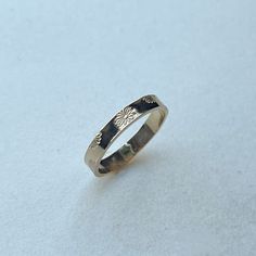 a silver ring sitting on top of a white surface