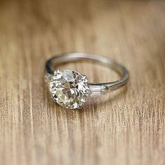 a diamond ring sitting on top of a wooden table