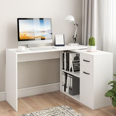 a white desk with a computer on it in front of a window and a potted plant