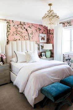 a bedroom decorated in pink and white with a chandelier hanging from the ceiling