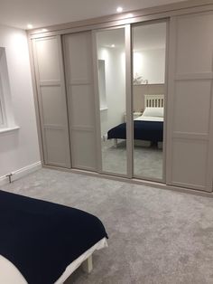 an empty bedroom with sliding doors leading to a bed and a large mirror on the wall