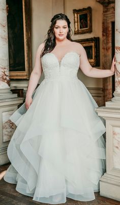 a woman in a wedding dress posing for the camera