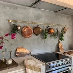 pots and pans are hanging on the wall above an oven