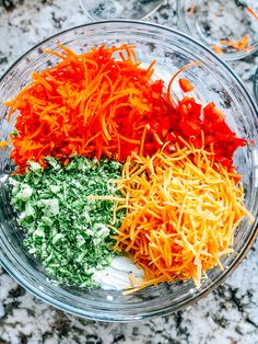 carrots, parmesan cheese and other ingredients in a glass bowl on a marble surface