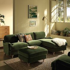 a green couch and ottoman in a living room