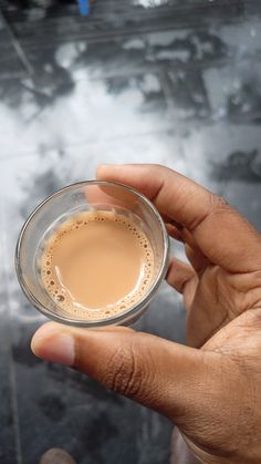 a person holding a cup of coffee in their hand