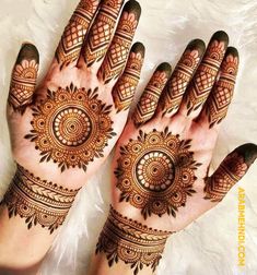 two hands with henna tattoos on them