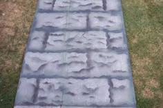 a cement walkway in the middle of some grass