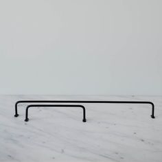 a white marble counter top with black metal bars on the bottom and one bar in the middle