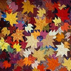 an image of a quilt made with many different colors and shapes in the shape of stars