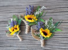 three sunflowers and lavender boutions tied to burlocks on a wooden surface