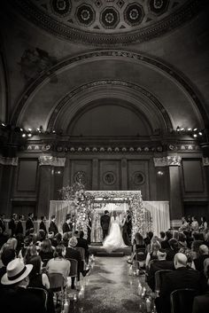 a black and white photo of a bride and groom at their wedding ceremony in an ornate building