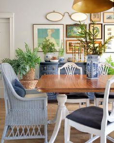 a dining room table with chairs and pictures on the wall in the backround