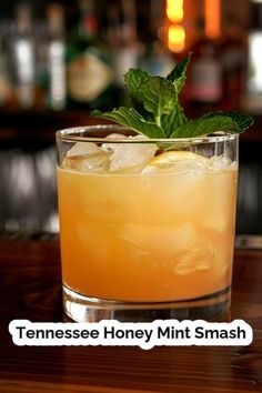 a glass filled with a drink sitting on top of a wooden table