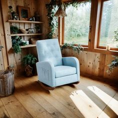 a blue rocking chair sitting in front of a window