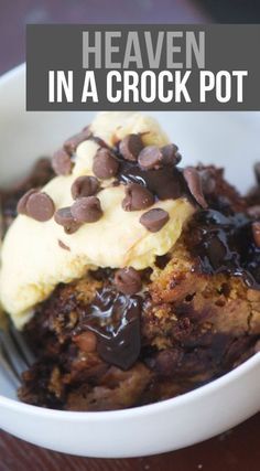 a white bowl filled with pudding and ice cream on top of a wooden table next to a fork